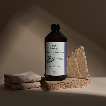 Bottle of natural laundry liquid with a towel and stone on a neutral background