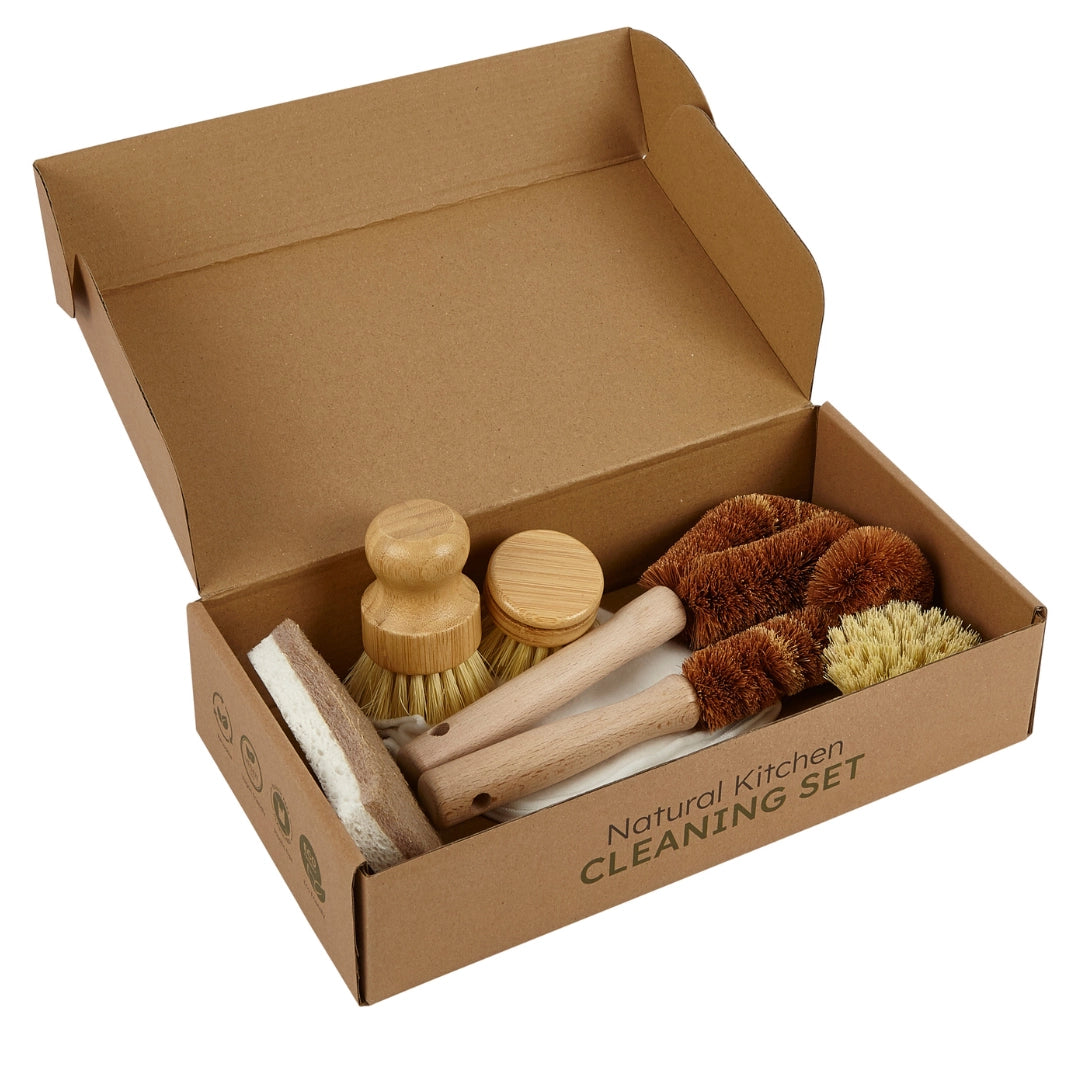An open brown cardboard box labeled 'Natural Kitchen Cleaning Set' containing a set of wooden-handled cleaning brushes and scrubbers on a white background.