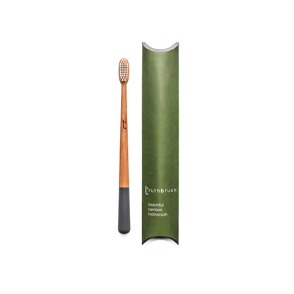 Bamboo toothbrush with green holder on a white background