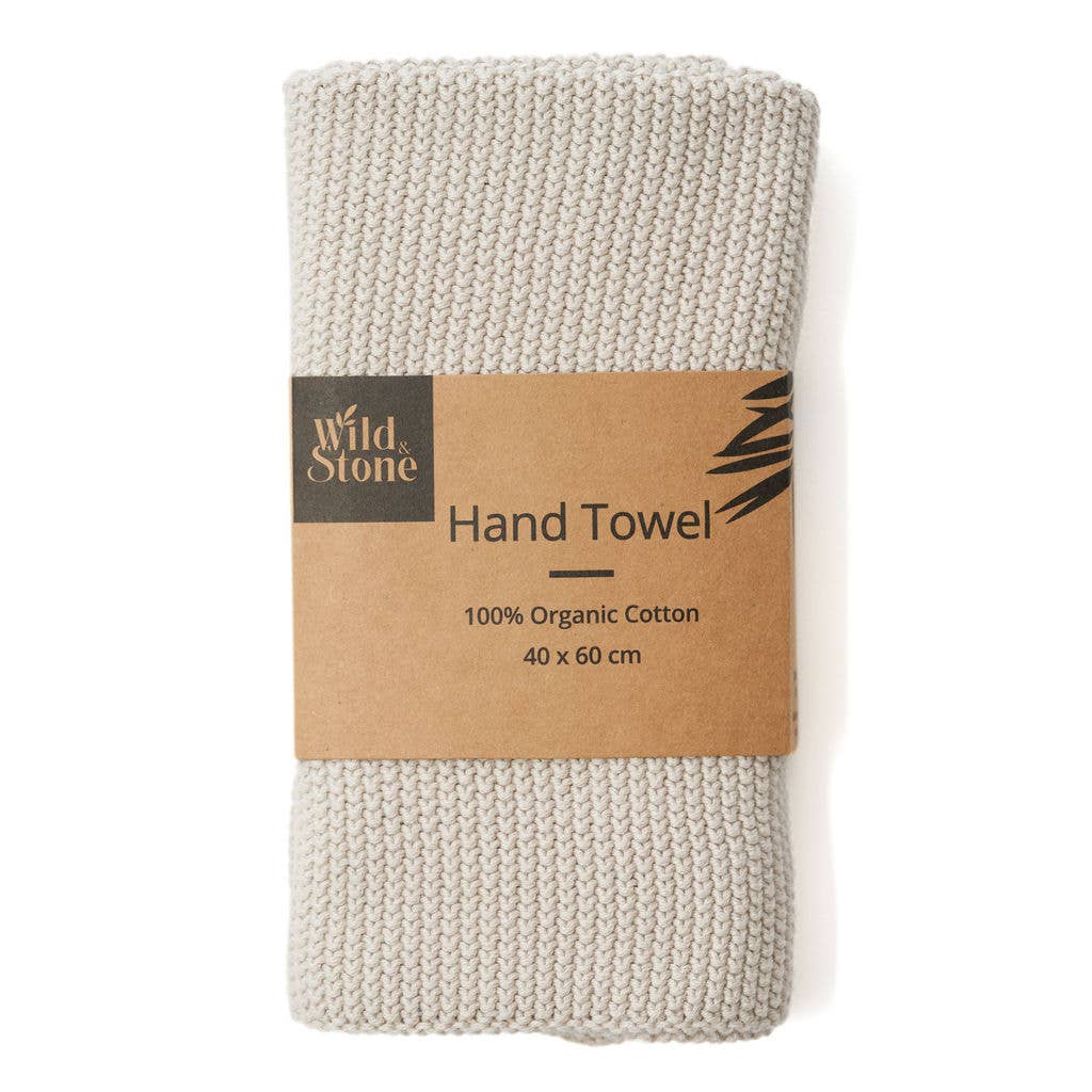 Folded beige hand towel with a brown label on a white background
