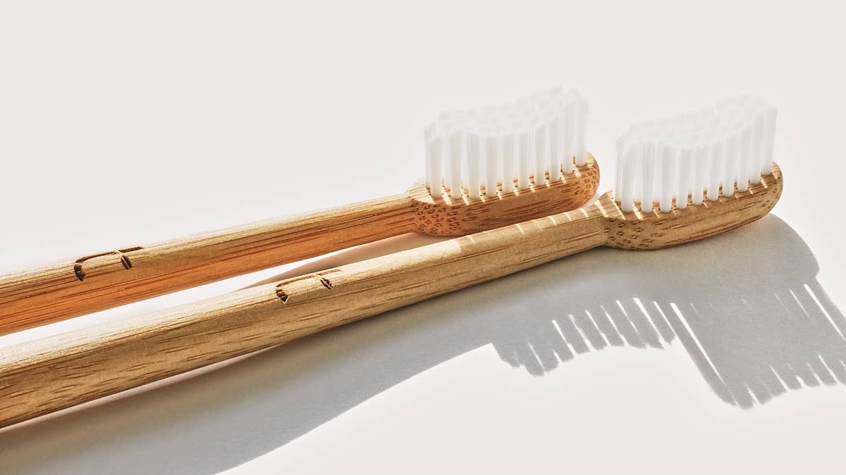 Two bamboo toothbrushes with clear plastic-free bristles on a light background