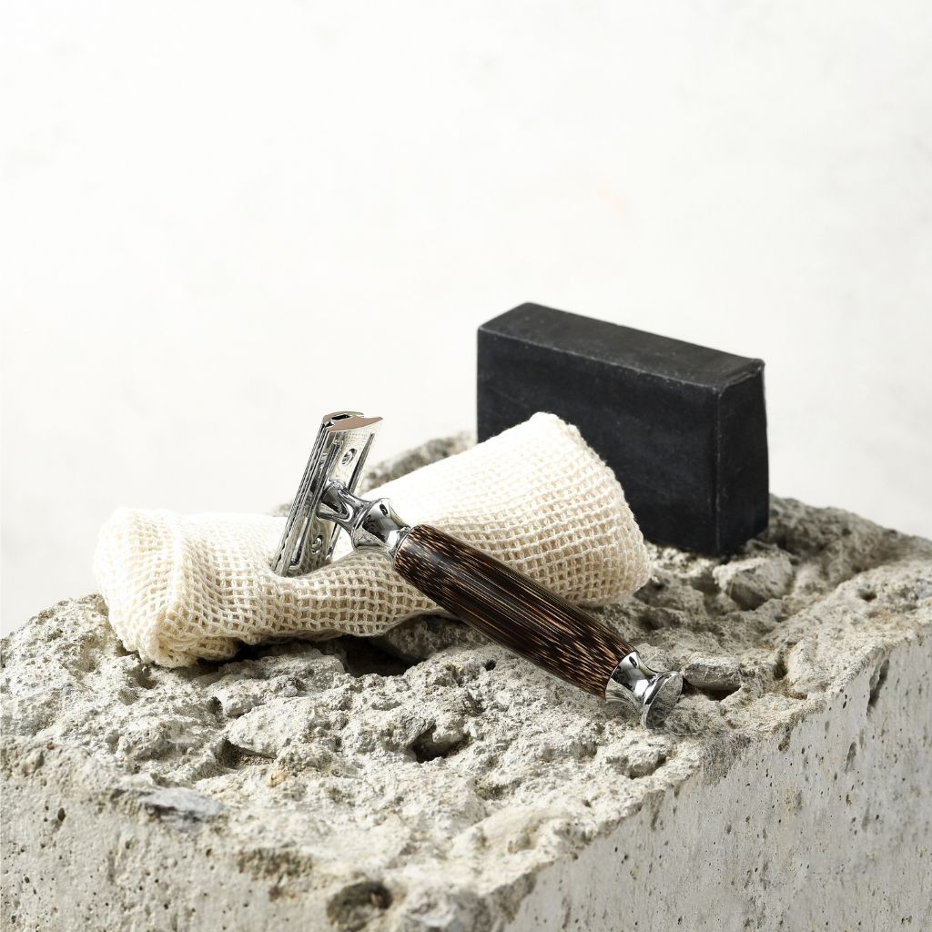 Shaving razor and soap on a stone surface with a white background