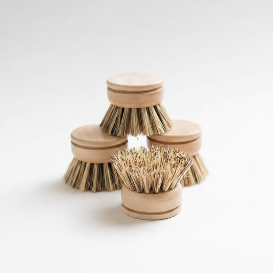 Set of wooden dish brushes with natural bristles on a light surface