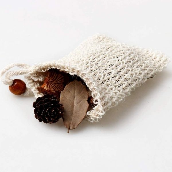 Textured white bag with natural elements like a leaf and pine cone on a light background