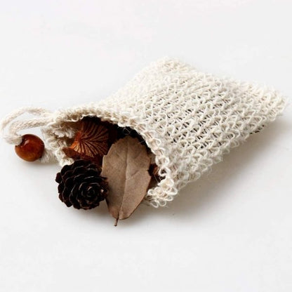 Textured white bag with natural elements like a leaf and pine cone on a light background