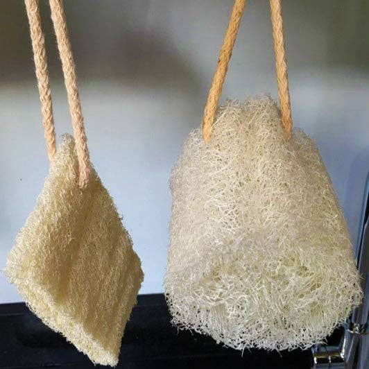 Two plant-based loofah sponge bath brushes with rope handles, shown hanging against a light gray background.