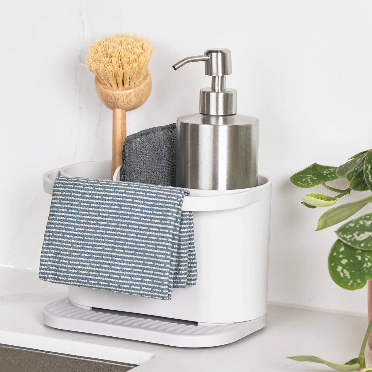 Recycled White kitchen organizer with soap dispenser, scrubber, and cloth on a white surface.